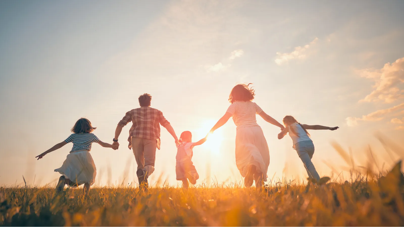 Familia caminando de la mano al atardecer